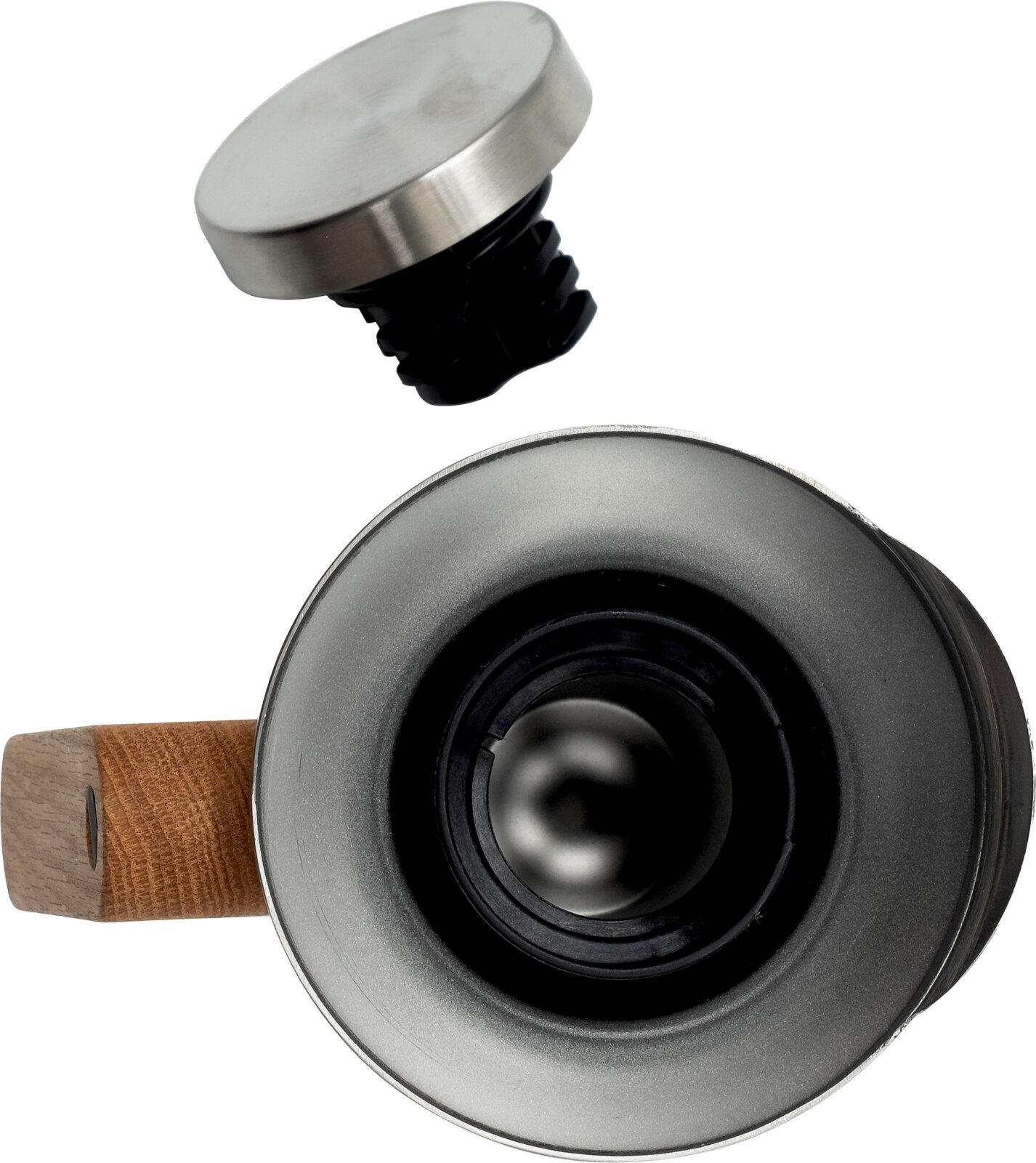Close-up van een roestvrijstalen ronde dop met zwarte kunststof plug, schuin van boven gefotografeerd; onderaan is de onderzijde van een cilindrisch onderdeel met houten handgreep zichtbaar.
