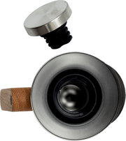 Close-up van een roestvrijstalen ronde dop met zwarte kunststof plug, schuin van boven gefotografeerd; onderaan is de onderzijde van een cilindrisch onderdeel met houten handgreep zichtbaar.