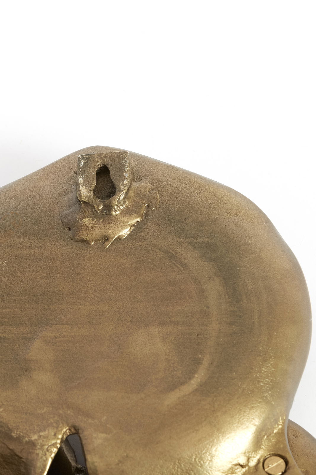 Nahaufnahme eines goldfarbenen Wandornaments mit Aufhängung, Rückansicht