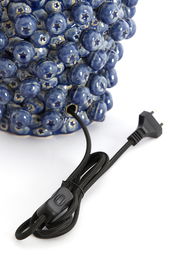 Nahaufnahme eines blauen Lampenfußes mit kugelförmigen Verzierungen und einem schwarzen Kabel mit Schalter, seitliche Perspektive.