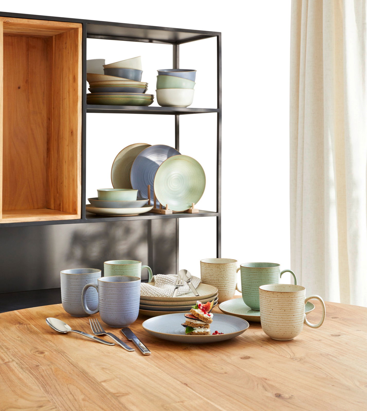 Kaffeeset Nature 18-tlg. auf einem Holztisch, bestehend aus Tassen, Tellern und Schalen in natürlichen Farben, seitliche Perspektive.