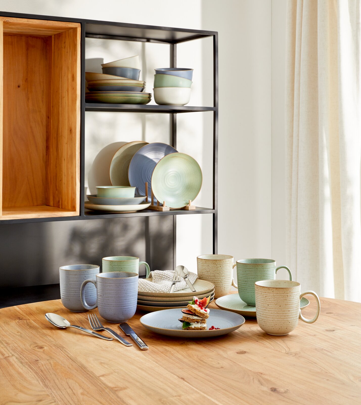 Kaffeeset Nature 18-tlg. auf einem Holztisch, bestehend aus Tassen, Tellern und Schalen in natürlichen Farben, seitliche Perspektive.
