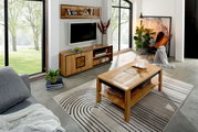 Modernes Wohnzimmer mit rechteckigem Couchtisch aus hellem Holz mit Ablagefach auf gemustertem Teppich, im Hintergrund TV-Board und Wandregal; Perspektive: leicht erhöhte, schräge Frontansicht von links.