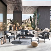 Moderne Loungegarnitur in einem stilvollen Außenbereich mit Wüstenlandschaft im Hintergrund, aus der Perspektive von vorne aufgenommen.