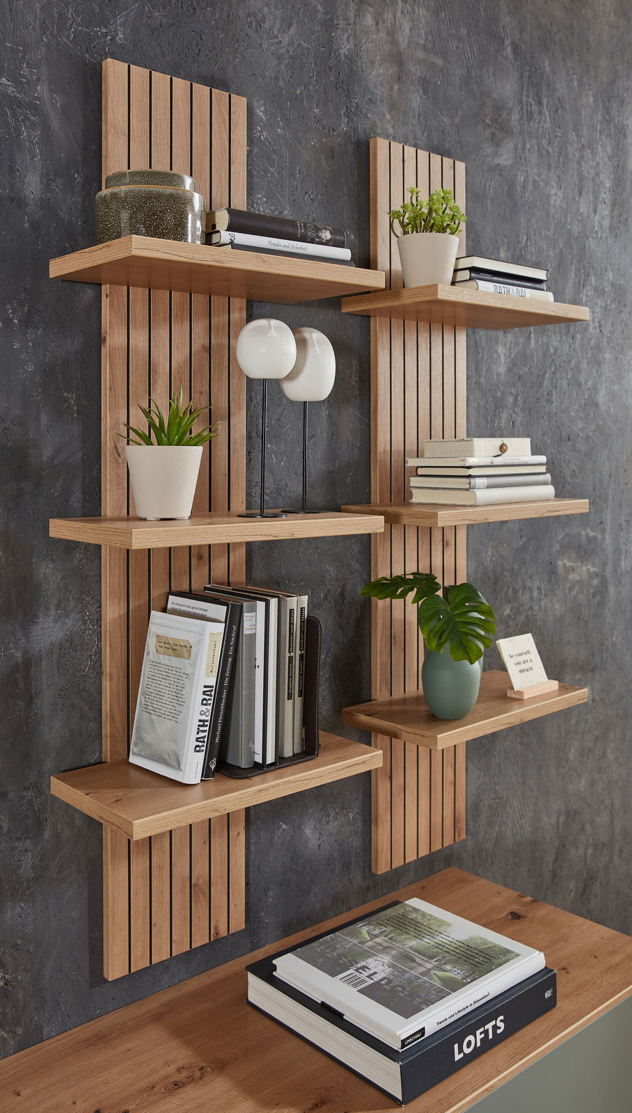 Wandpaneel mit Holzregalen, dekoriert mit Büchern und Pflanzen, seitliche Perspektive