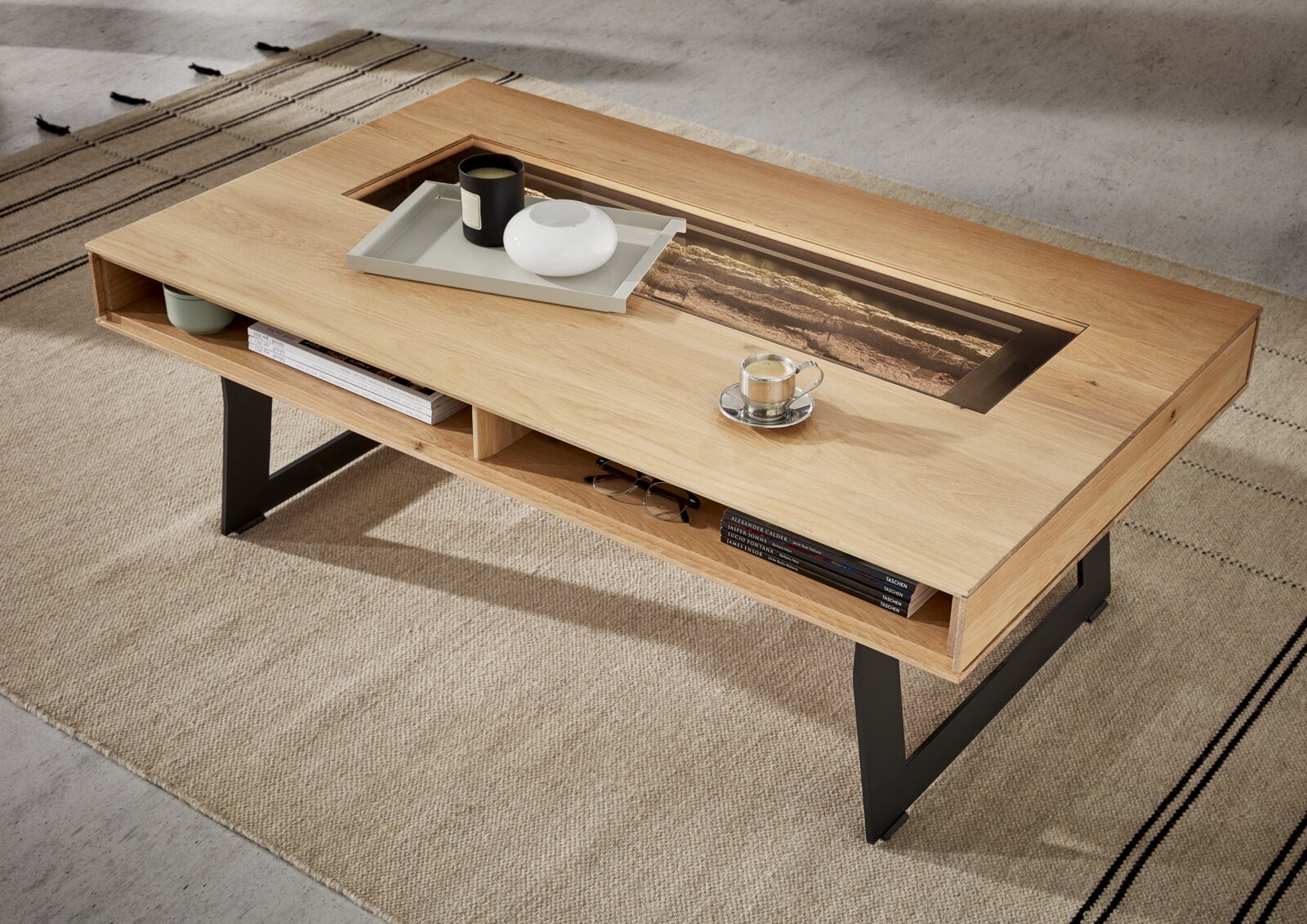 Moderner Couchtisch aus Holz mit schwarzem Metallgestell, von oben fotografiert, mit dekorativen Gegenständen auf der Tischplatte.