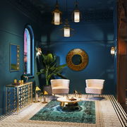 Zwei elegante Sessel in einem luxuriösen, orientalisch inspirierten Raum mit blauen Wänden, goldenen Akzenten und dekorativen Lampen, aus der Frontalperspektive betrachtet.