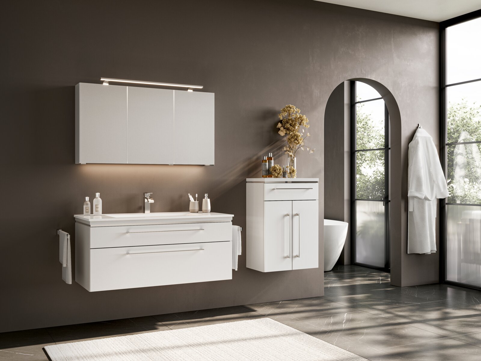 Modernes Badmöbel-Set in Weiß mit Waschtischunterschrank, Spiegelschrank mit LED-Leuchte und Hochschrank in Badezimmer-Szene, Ansicht schräg von vorn.