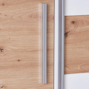 Nahaufnahme eines Dreh-Schwebetürenschranks mit Holzoptik und silbernen Griffen, seitliche Perspektive