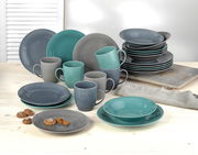 Kombiservice 24-teilig Jive in verschiedenen Grautönen und Türkis, bestehend aus Tellern, Schalen und Tassen, auf einem hellen Holztisch aus der Vorderansicht.