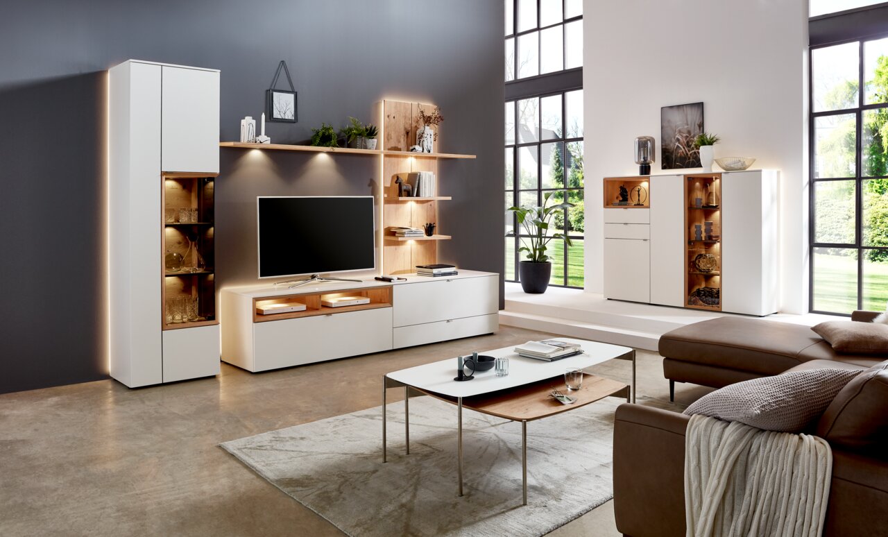 Venjakob Highboard ANDIAMO HOME Moderne Wohnzimmermöbelkombination mit LED-Beleuchtung, bestehend aus Vitrine, Wandregalen und TV-Schrank in einer stilvollen, hellen Umgebung. Perspektive von vorne.