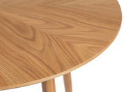 Nahaufnahme eines runden Esstisches aus Holz mit sichtbarer Maserung, von oben betrachtet.