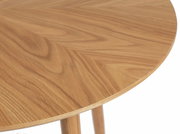 Nahaufnahme eines runden Esstisches aus Holz mit sichtbarer Maserung, von oben betrachtet.