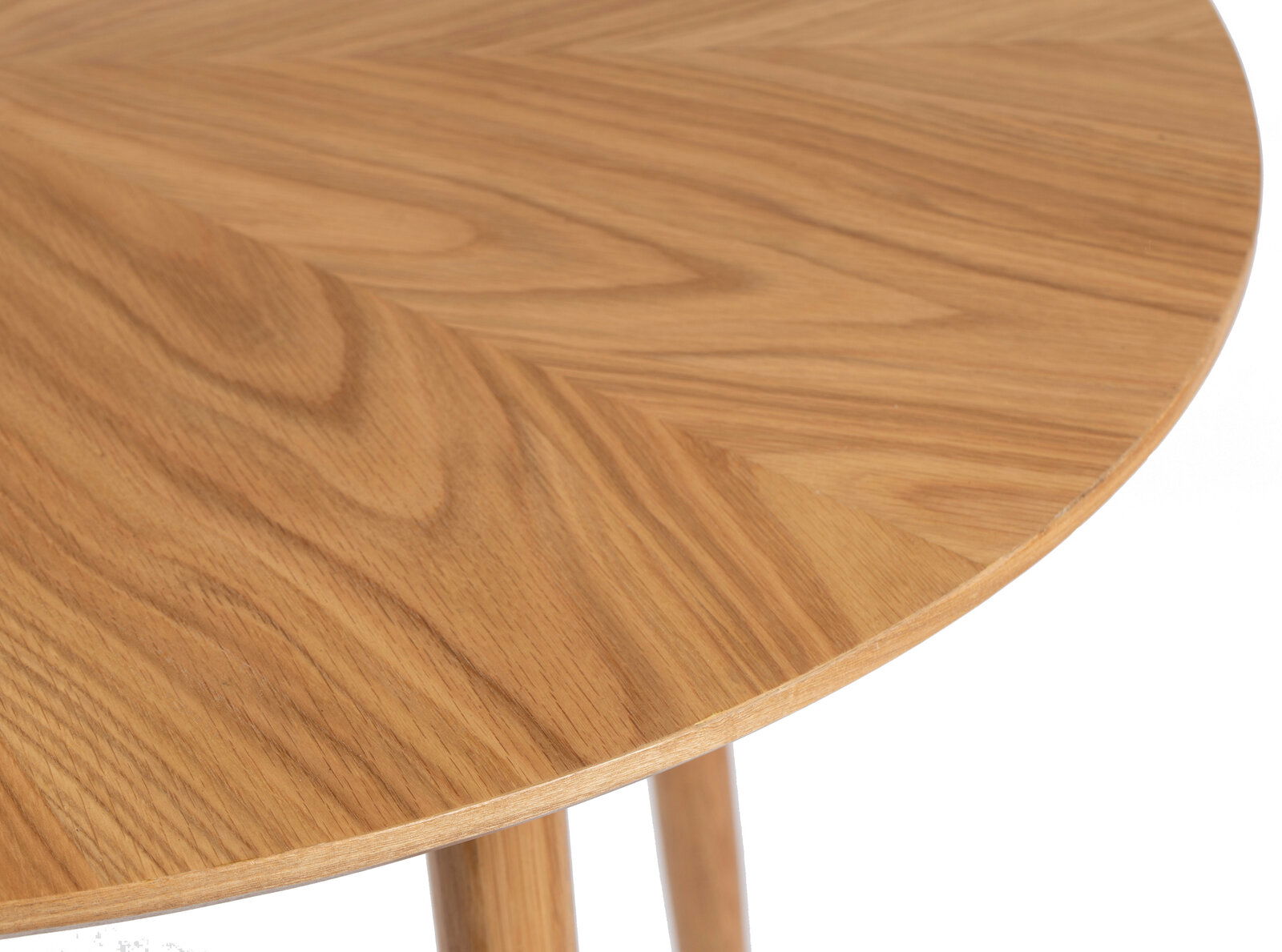 Nahaufnahme eines runden Esstisches aus Holz mit sichtbarer Maserung, von oben betrachtet.