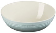 Hellblaue Le Creuset Keramikschale mit cremeweißem Innenraum, freigestellt vor weißem Hintergrund, in seitlicher Frontansicht leicht von oben