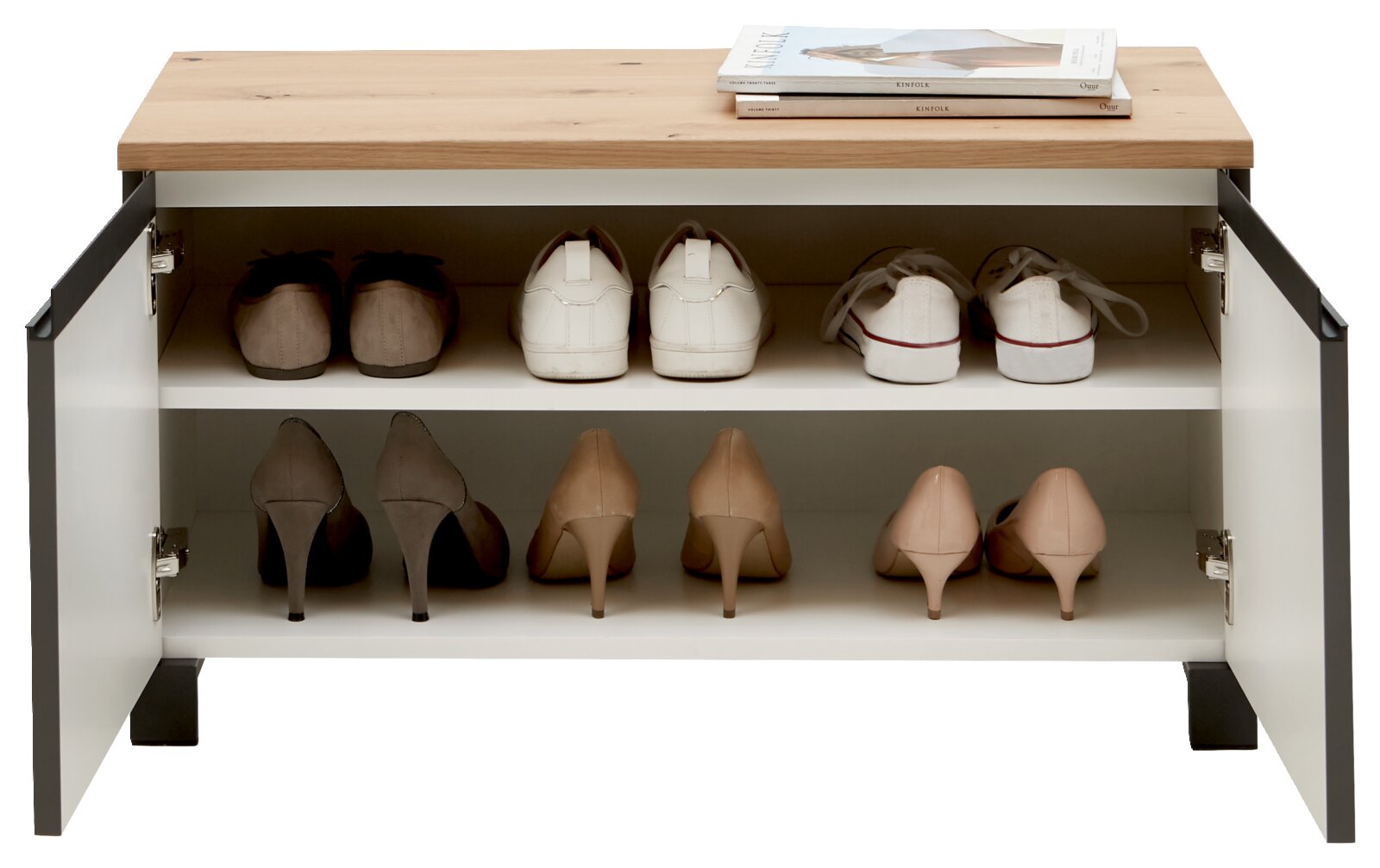 Schuhschrank mit zwei offenen Türen, gefüllt mit verschiedenen Schuhen, aus der Frontperspektive fotografiert. Obenauf liegen zwei Zeitschriften.