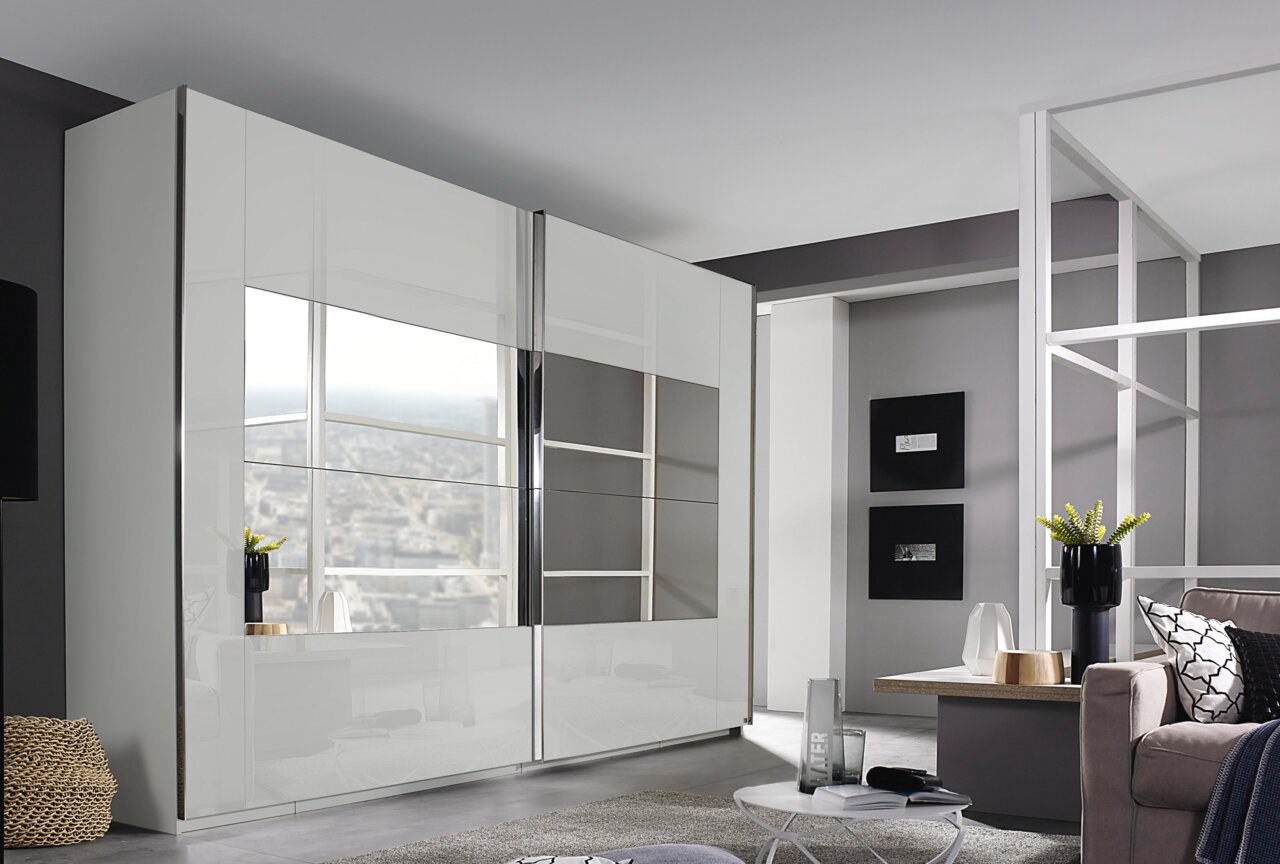 Moderner Schwebetürenschrank in Weiß mit Spiegeln, seitliche Perspektive im stilvollen Wohnzimmer.