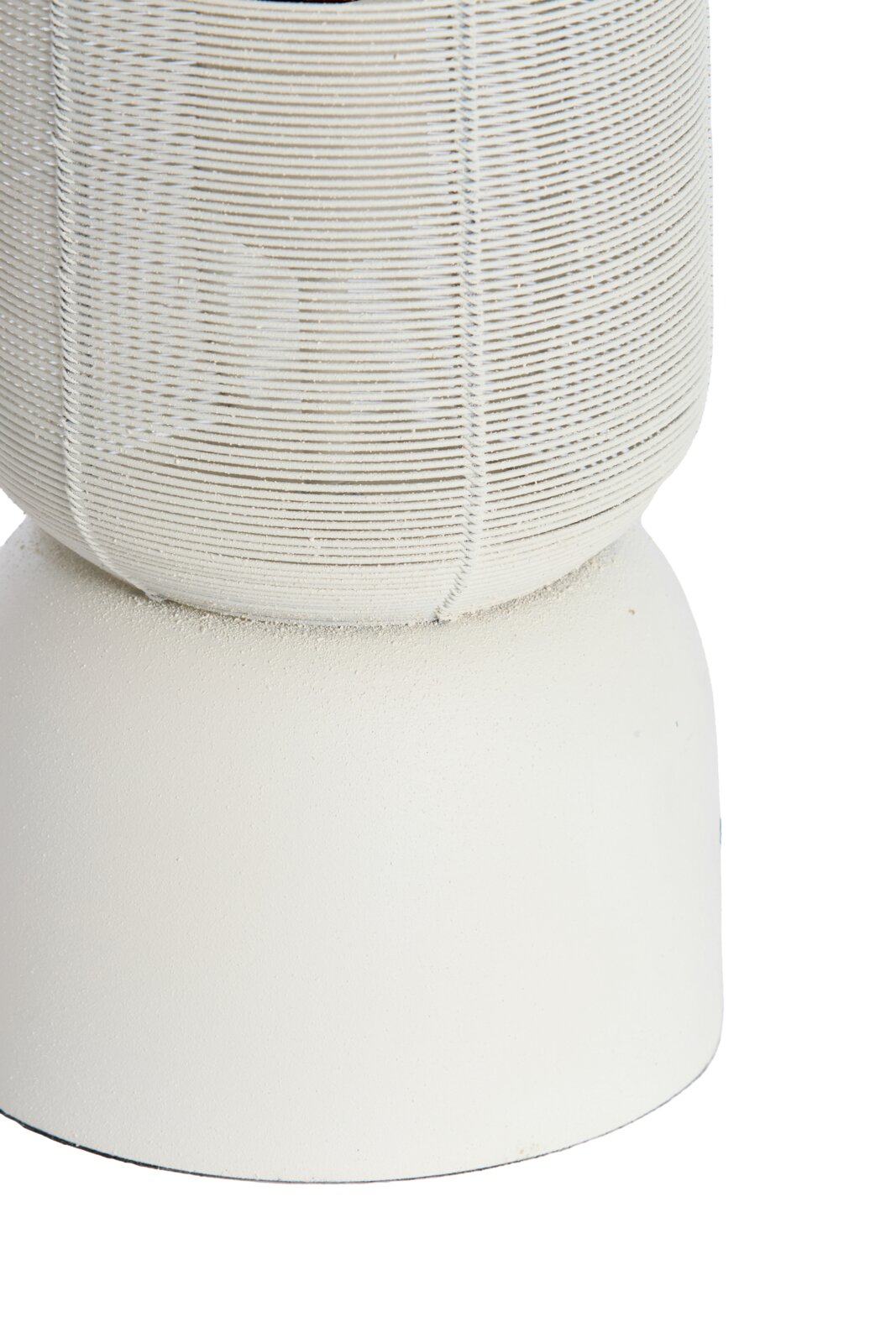 Close-up in vooraanzicht van een wit decoratief object met een bolvormig, fijn gevlochten bovendeel en een matte, taps toelopende voet.
