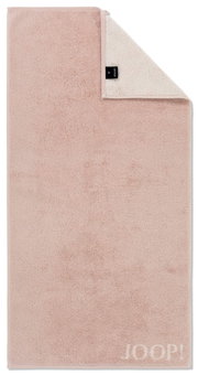 Beiges Handtuch mit umgeschlagener Ecke, Markenlabel sichtbar, Draufsicht