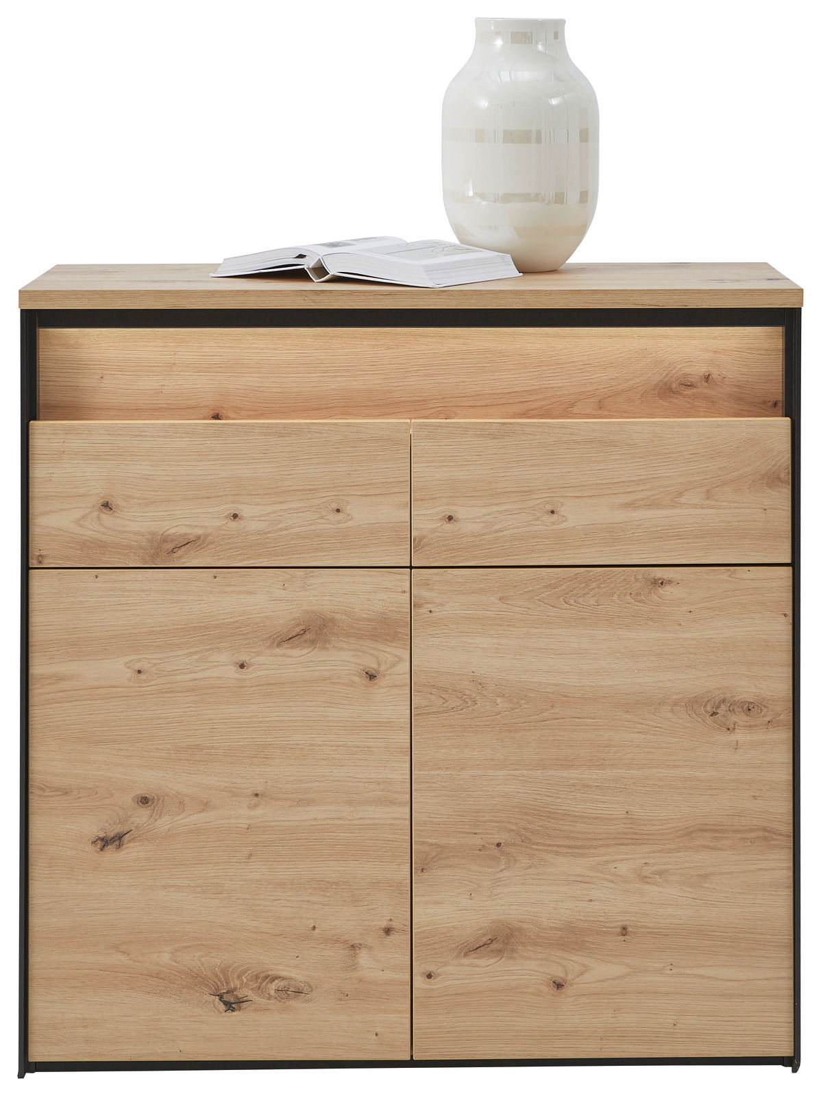Kommode aus hellem Holz mit zwei Schubladen und zwei Türen, darauf eine geöffnete Zeitschrift und eine weiße Vase, frontale Ansicht.