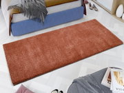 Roter Uni-Teppich in einem modernen Schlafzimmer, aus der Vogelperspektive fotografiert.