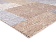 Nahaufnahme eines Frisé-Teppichs in Beige- und Grautönen, perspektivisch von der Seite aufgenommen.