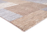 Nahaufnahme eines Frisé-Teppichs in Beige- und Grautönen, perspektivisch von der Seite aufgenommen.