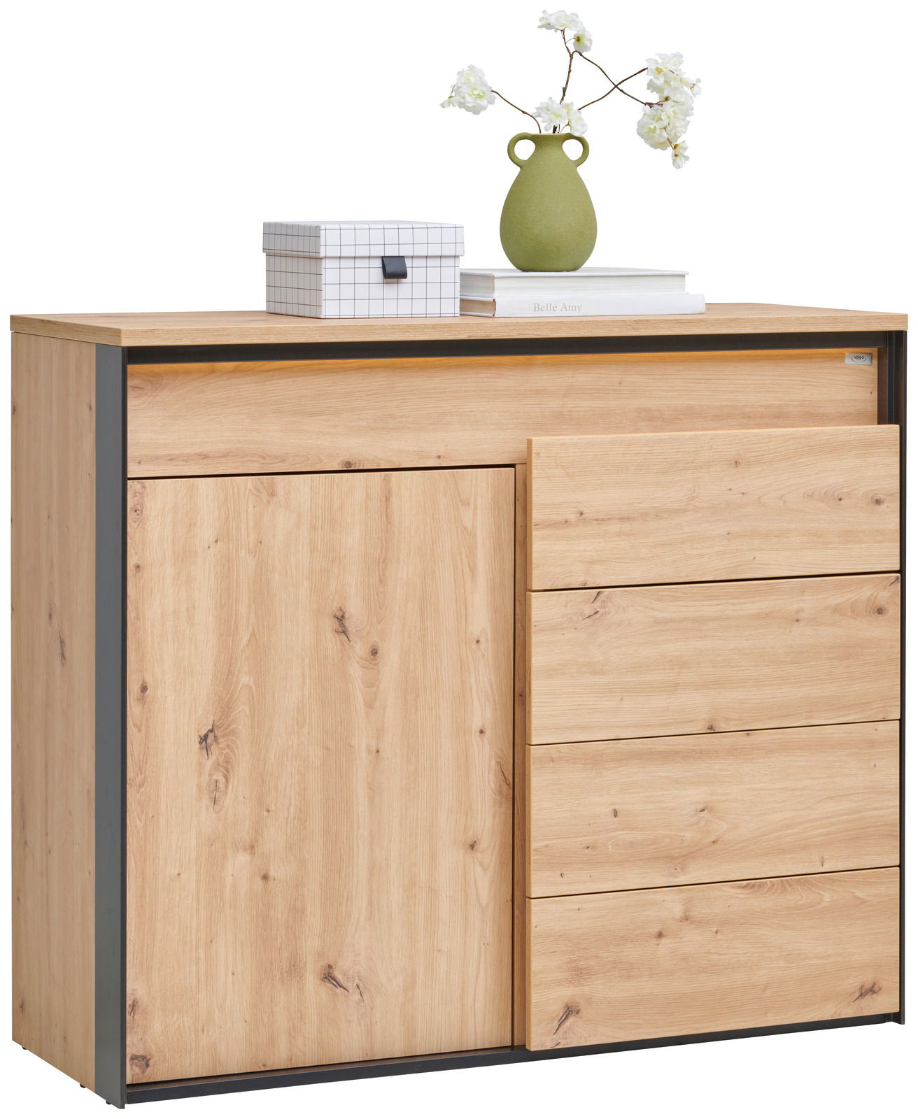Voleo Kommode Kommode aus hellem Holz mit drei Schubladen und einer Tür, dekoriert mit einer grünen Vase und einer Box, seitliche Perspektive