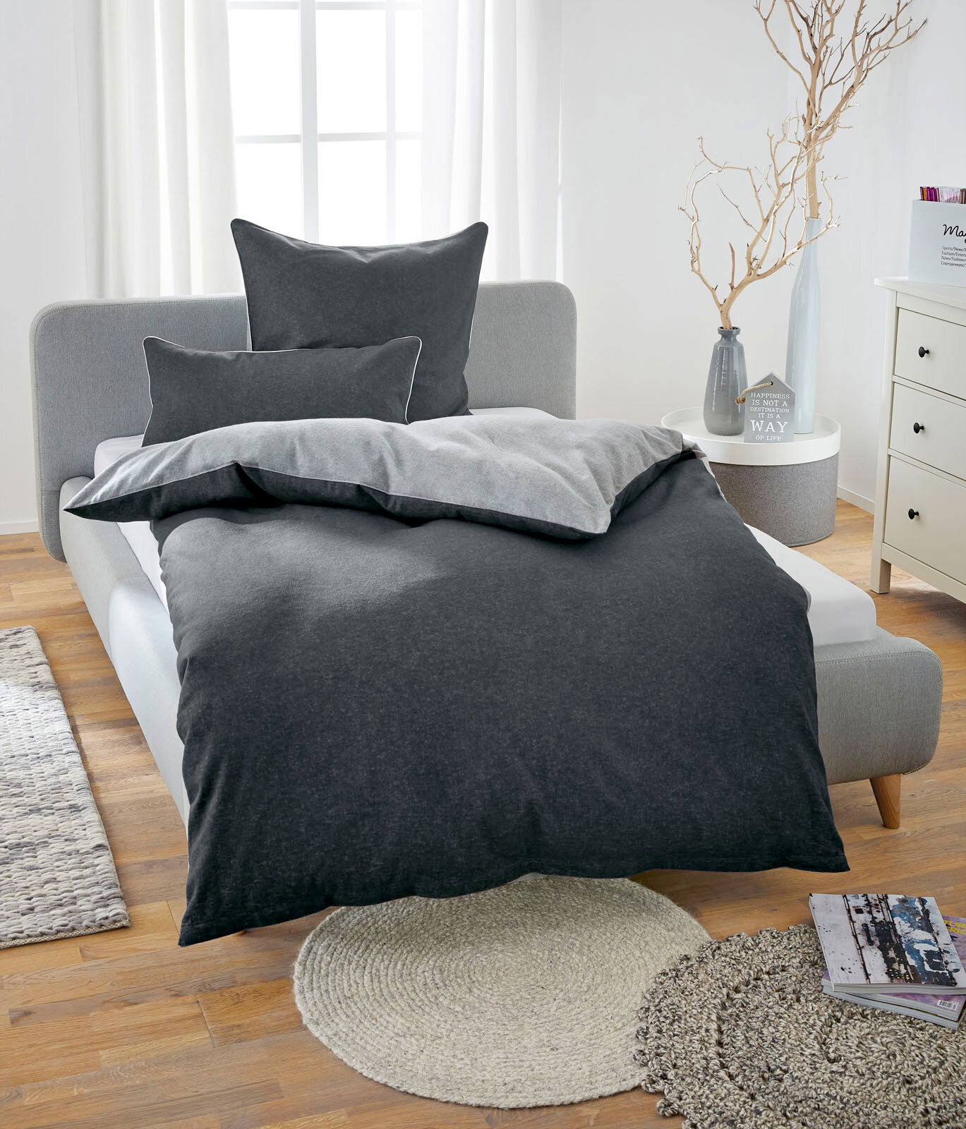 Bett mit grauer Melange-Flanell-Bettwäsche in einem hellen Schlafzimmer, Vorderansicht