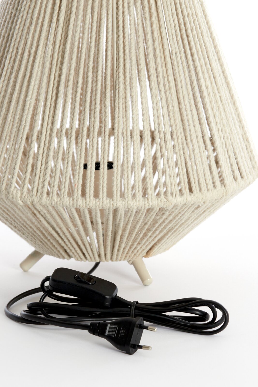 Nahaufnahme einer Tischleuchte mit einem Lampenschirm aus beigem Seilmaterial und einem schwarzen Kabel mit Schalter, von unten fotografiert.