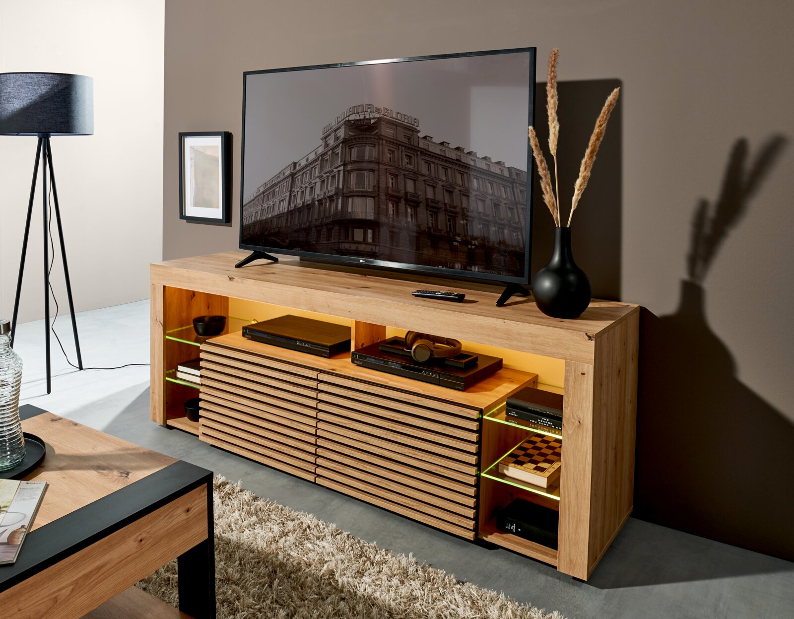 Z2 TV-Lowboard GOAL Modernes TV-Lowboard aus hellem Holz mit Lamellenfront, offenen Fächern und LED-Beleuchtung, mit Fernseher und Deko im Wohnzimmer, Perspektive: frontale Ansicht leicht von links