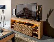 Modernes TV-Lowboard aus hellem Holz mit Lamellenfront, offenen Fächern und LED-Beleuchtung, mit Fernseher und Deko im Wohnzimmer, Perspektive: frontale Ansicht leicht von links