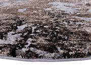 Nahaufnahme eines Designer-Teppichs mit abstraktem Muster in Brauntönen, aus seitlicher Perspektive fotografiert.