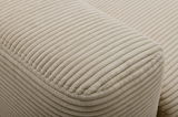 Nahaufnahme eines beigen, gerippten Stoffes eines Funktionssofas, seitliche Perspektive.