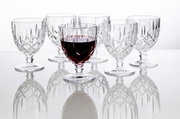 Sechs elegante Weinkelche Noblesse 350ml aus Kristallglas, einer davon mit Rotwein gefüllt, auf einer reflektierenden Oberfläche, seitliche Perspektive.