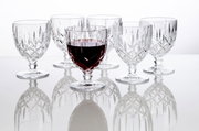 Zes elegante Noblesse-wijnglazen van 350 ml van kristalglas, waarvan één gevuld met rode wijn, op een spiegelend oppervlak, gezien vanuit de zijkant.
