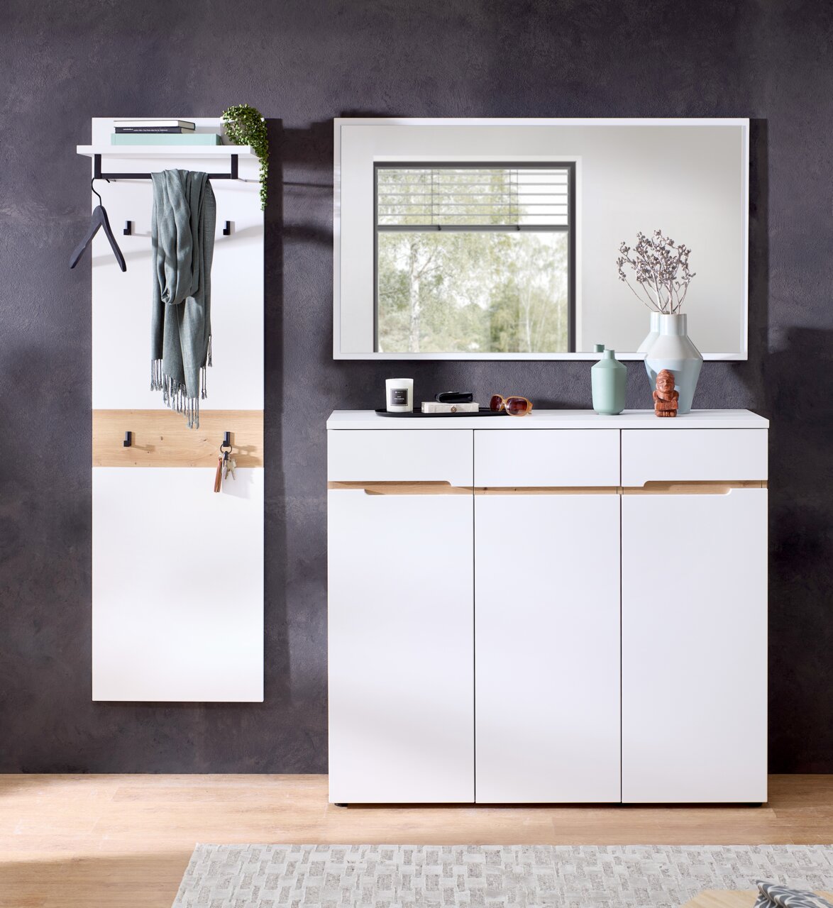 Moderne Garderobenkombination mit weißem Garderobenpaneel, Spiegel und Schuhschrank, frontal fotografiert.