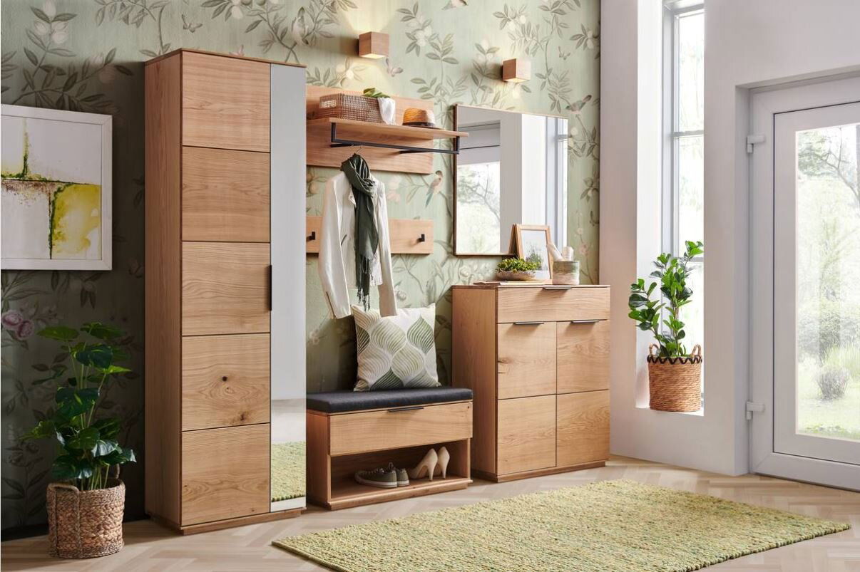 Moderne Garderobeneinrichtung aus Holz mit Schuhschrank, Spiegel, Garderobenbank und Hakenleiste in einem hellen Raum mit Pflanzen, aus frontaler Perspektive.