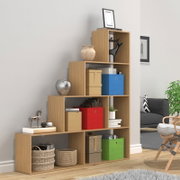 Modernes, stufenförmiges Holzregal mit offenen Fächern und farbigen Aufbewahrungsboxen sowie Deko-Objekten, fotografiert in leichter Frontansicht aus schrägem Winkel im Wohnzimmer.
