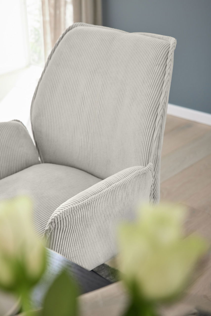 Nahaufnahme eines grauen Armlehnstuhls mit geripptem Stoffbezug, seitliche Perspektive
