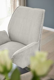 Nahaufnahme eines grauen Armlehnstuhls mit geripptem Stoffbezug, seitliche Perspektive