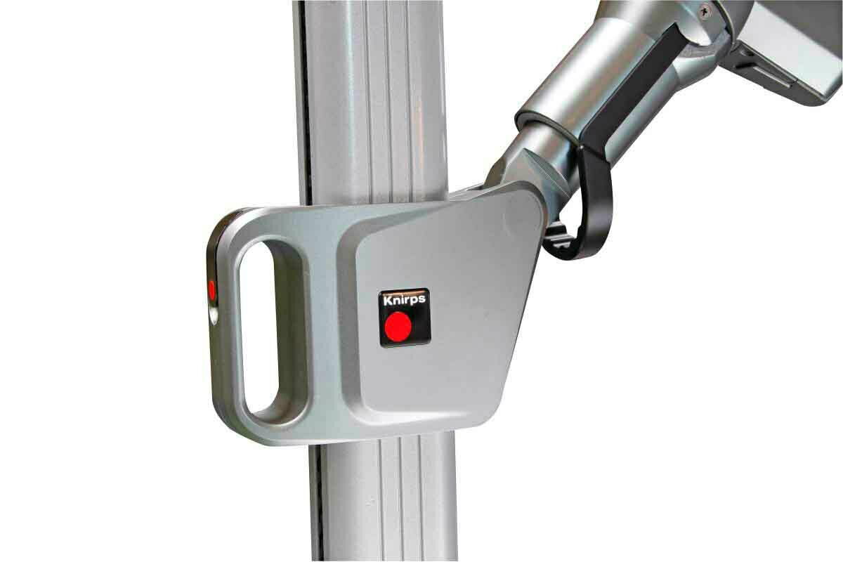 Nahaufnahme des Gelenks eines silbernen Pendelschirms mit Knirps-Logo, seitliche Perspektive