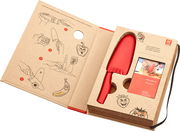 Kinderkochmesser in Rot, verpackt in einer offenen Box mit Anleitungen und Illustrationen, perspektivisch von oben fotografiert.