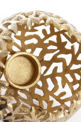 Nahaufnahme eines goldenen Teelichthalters mit filigranem, durchbrochenem Design von oben betrachtet.