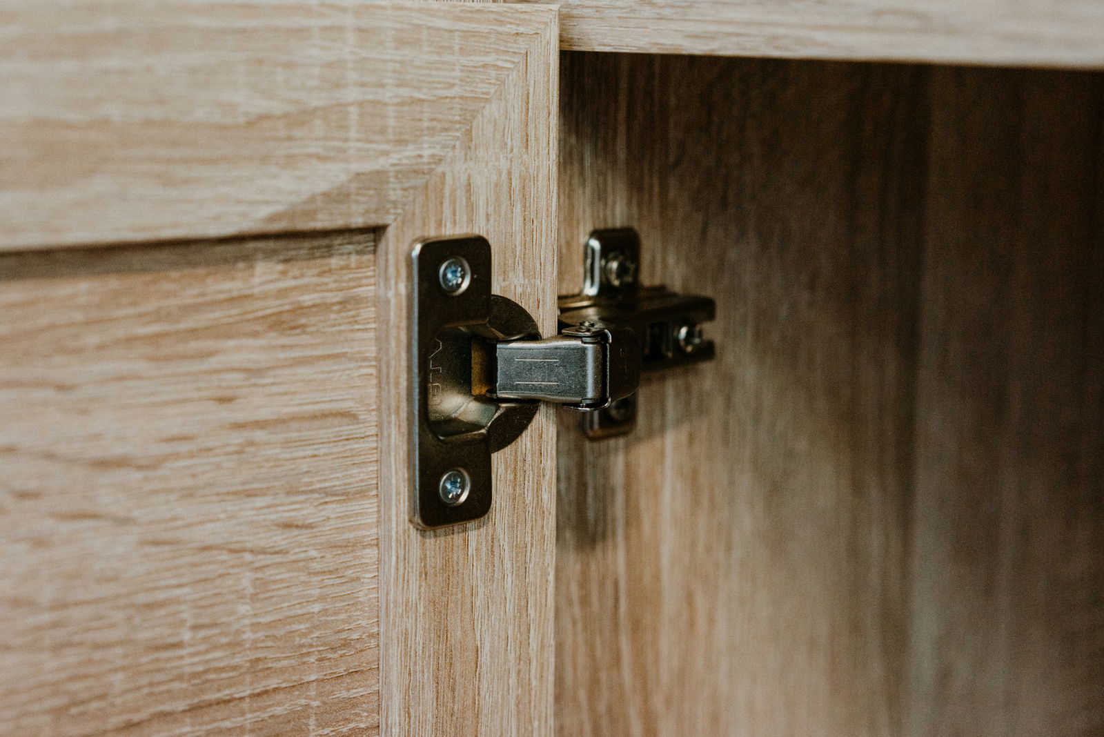 Nahaufnahme eines Scharniers an einer Holztür, Perspektive von innen.