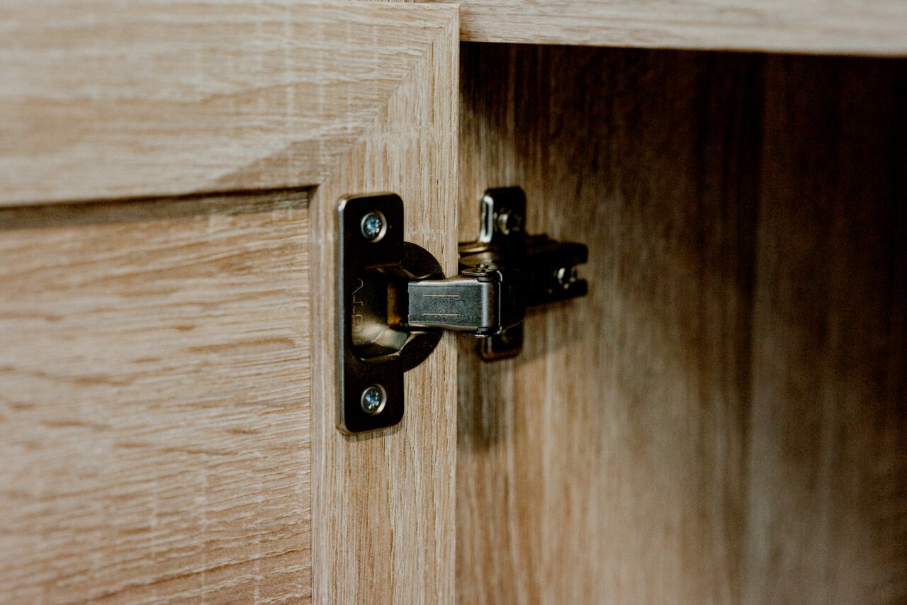 Nahaufnahme eines Scharniers an einer Holztür, Perspektive von innen.