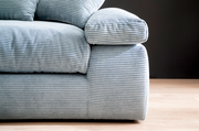 Nahaufnahme eines Big-Sofas mit geripptem Stoffbezug in hellblau, seitliche Perspektive.