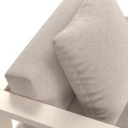 Nahaufnahme eines Lounge-Sessels mit beigem Stoffbezug und cremefarbenem Rahmen, von oben betrachtet.