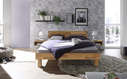 Modernes Schlafzimmer mit einem Bett aus Holz und Metall, frontal fotografiert. Das Kopfteil ist aus Holz, umgeben von stilvollen Nachttischen und Dekorationen.
