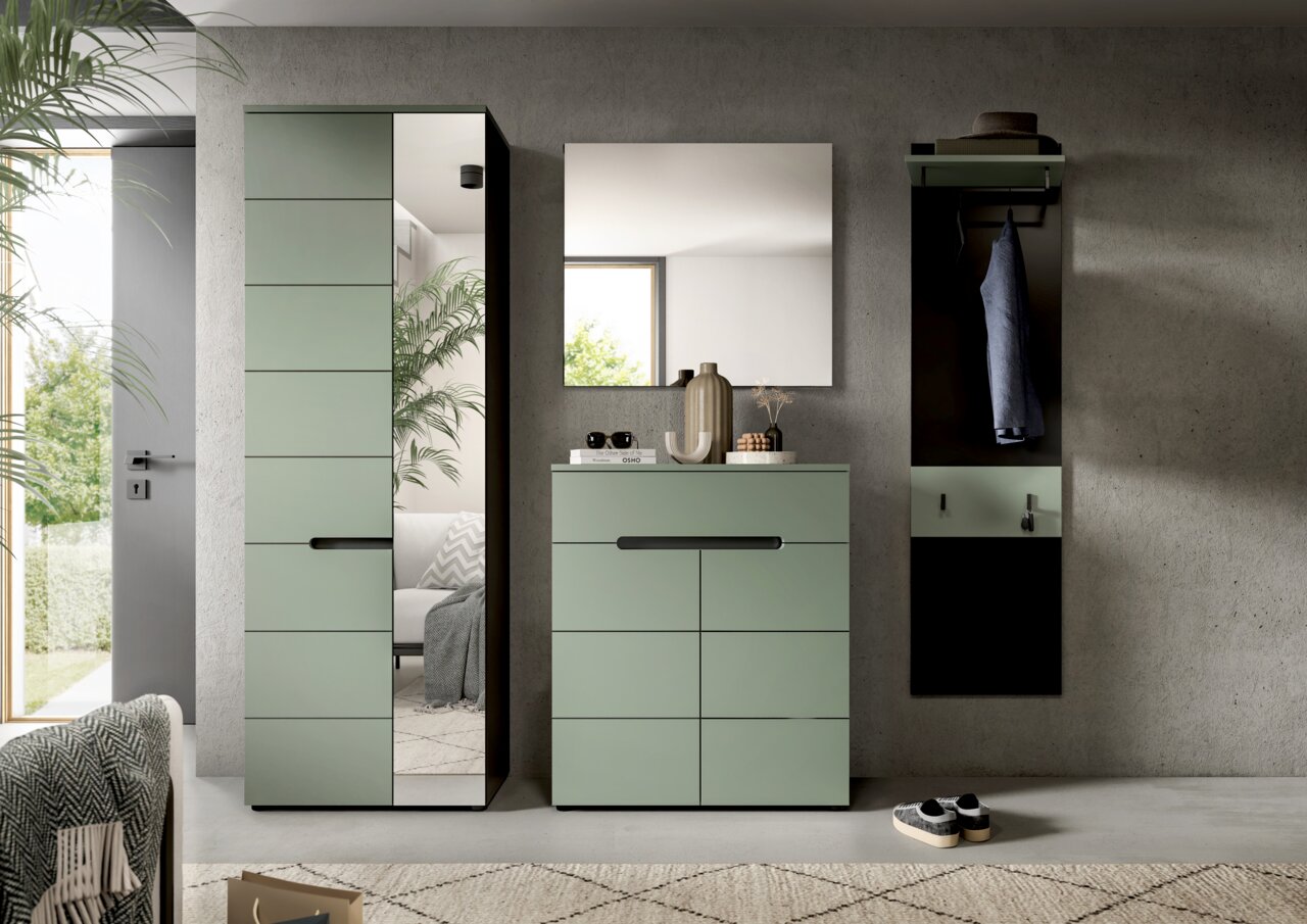 Modernes Flurmöbel-Set in Salbeigrün mit schwarzem Griff: hoher Schrank mit Spiegeltür, Kommode mit Schubladen und Wandspiegel sowie Garderobenpaneel mit Haken; frontale Perspektive.